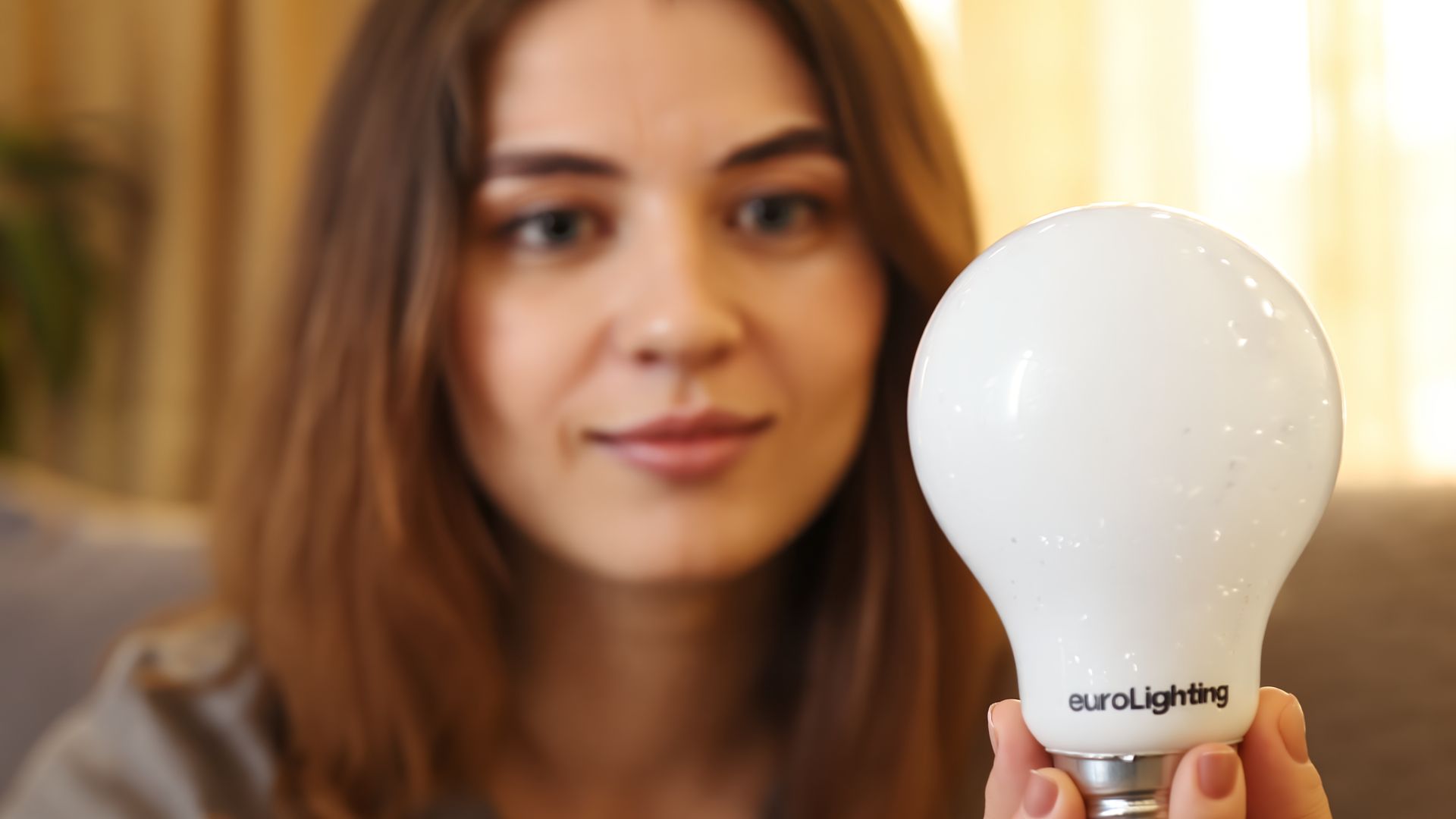 Žena drží Plnospektrální LED žárovku euroLighting