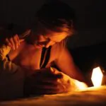 Maminka kojí dítě a u toho jí svítí noční světlo ORANŽOVKA