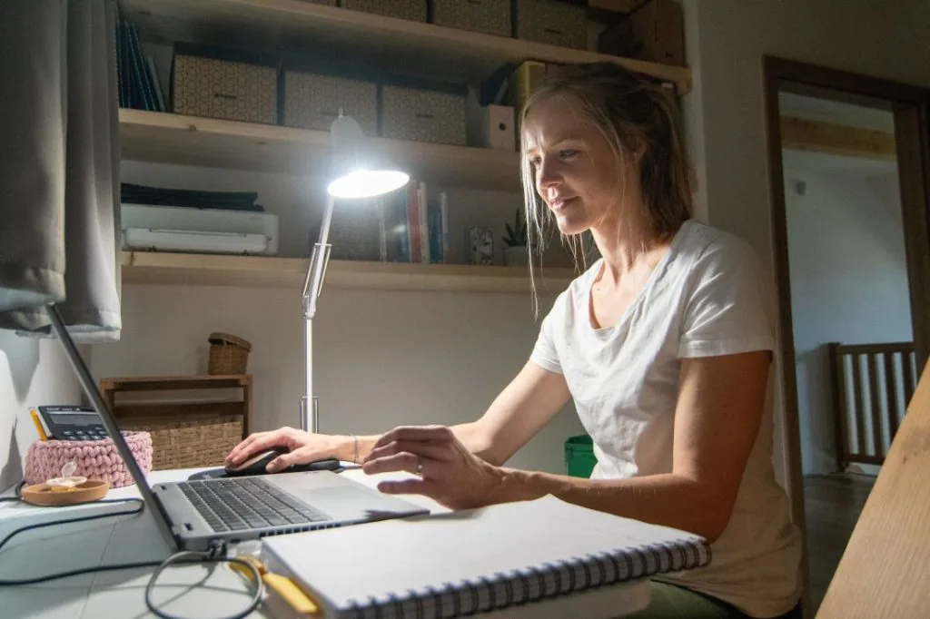Žena pracuje a vedle svítí denní LED žárovka ORANŽOVKA.