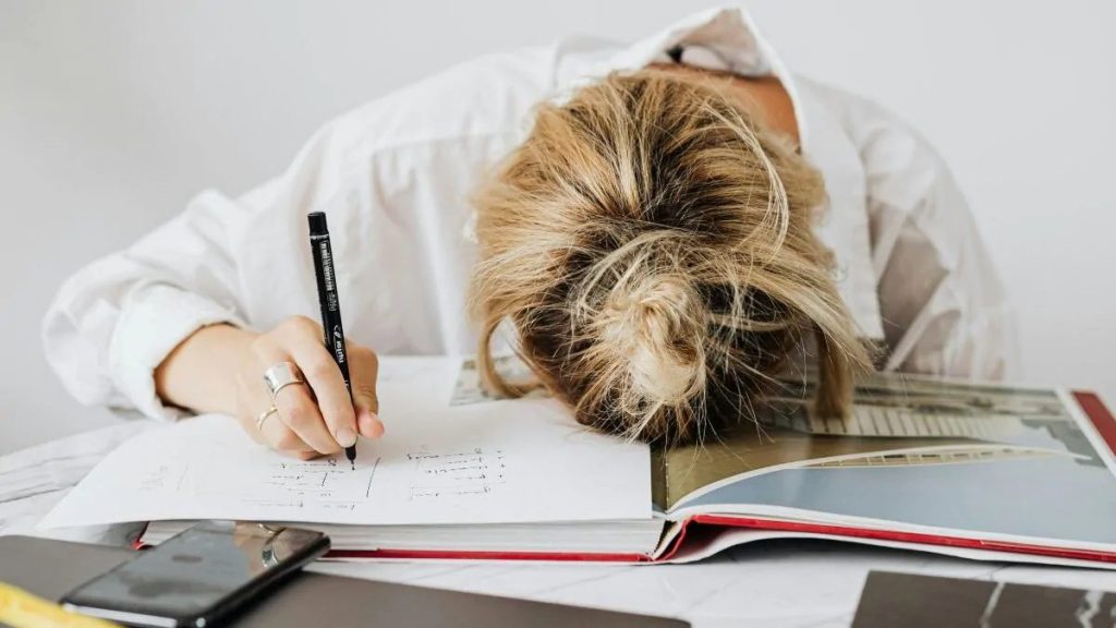 Unavená žena leží na otevřené knize papírů