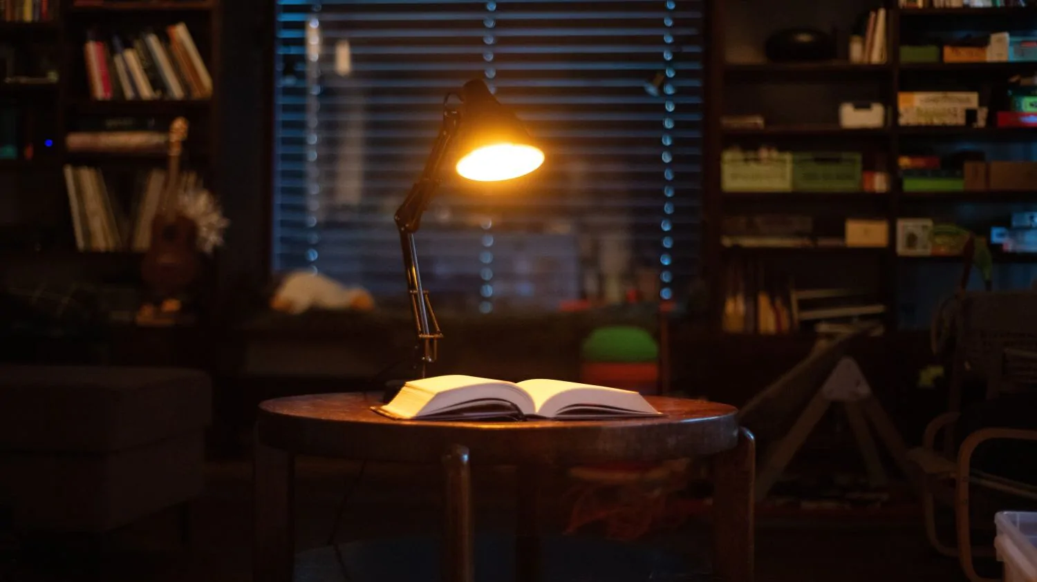 Lampa svítí na otevřenou knihu, která je na stole